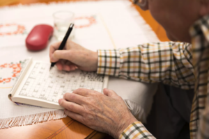 Elderly man doing a crossword puzzle