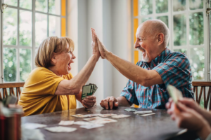Man and woman, senior couple playing cards