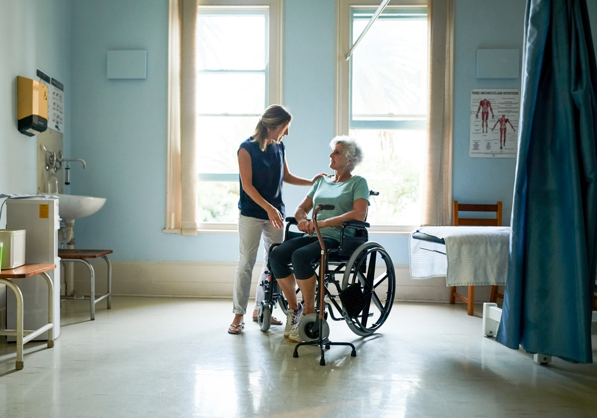 daughter helps elderly mother in wheelchair