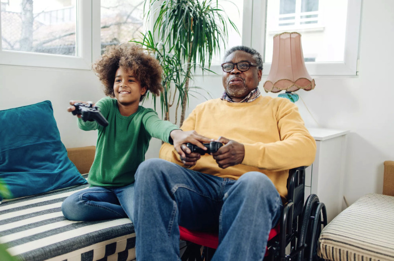 African American granddaughter and grandfather playing video games.